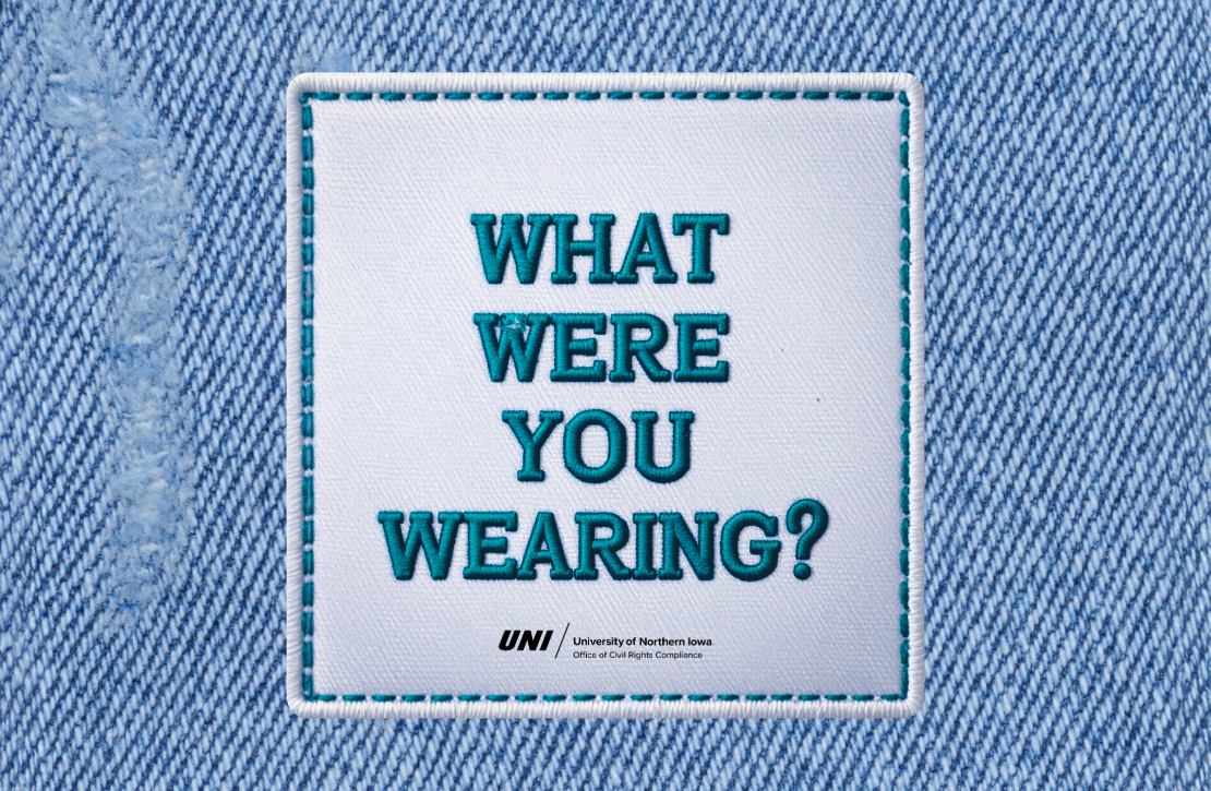 an image of a white iron on patch on a denim background. In teal lettering the iron on patch reads, "What Were You Wearing?".